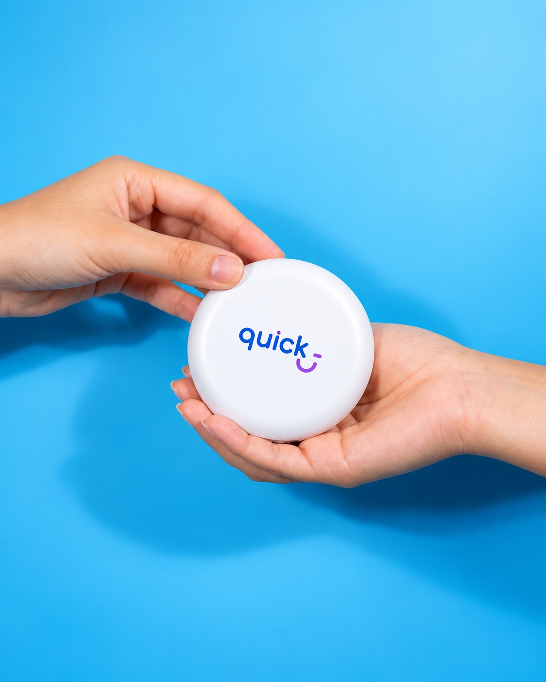 Estuche blanco de alineadores con el logo de Quick, sostenido entre dos manos